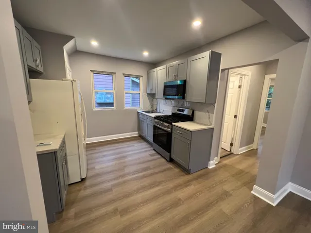 a kitchen with a refrigerator a stove top oven a sink and a refrigerator