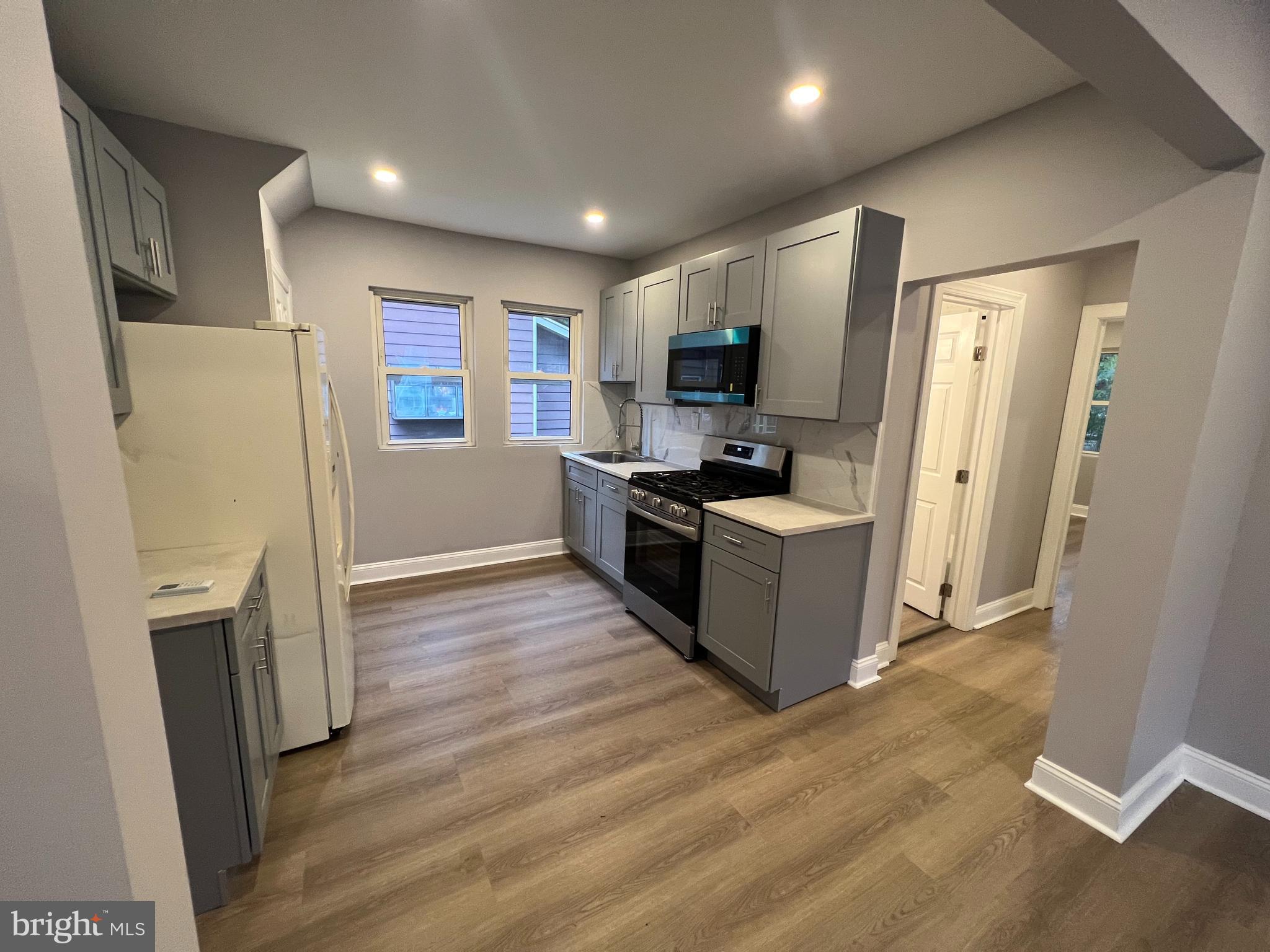 1301 Newton Avenue, Unit A Haddon Township, NJ 08107 - Photo 4 of 13 a kitchen with a refrigerator a stove top oven a sink and a refrigerator