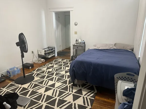 a bedroom with a bed and a mirror on the dresser