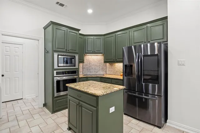 a kitchen with stainless steel appliances granite countertop a refrigerator and a sink