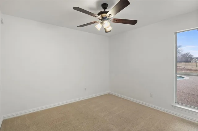 an empty room with a chandelier fan
