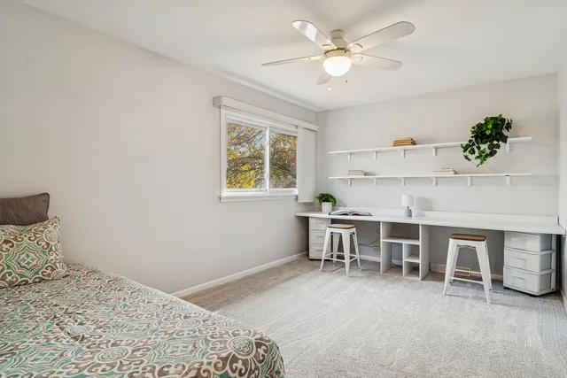 a bedroom with a bed a window and a chandelier