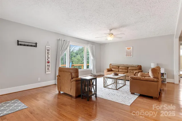 a dining room with wooden floor a chandelier a glass table and chairs