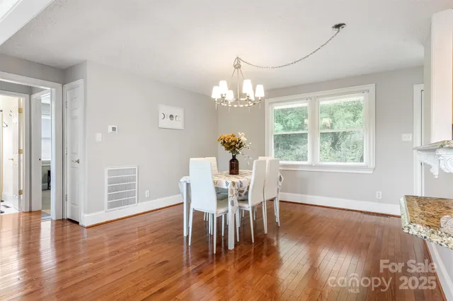 a dining room with furniture a chandelier and wooden floor