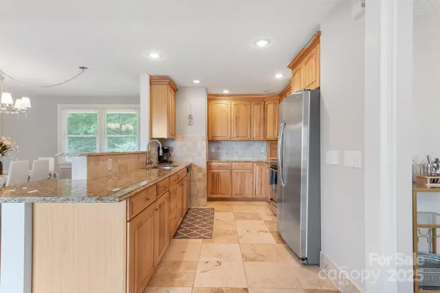 a large white kitchen with a large window and stainless steel appliances