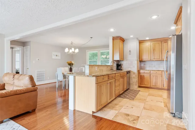 a kitchen with granite countertop a sink stainless steel appliances and cabinets