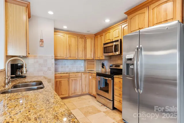 a kitchen with granite countertop sink and cabinets