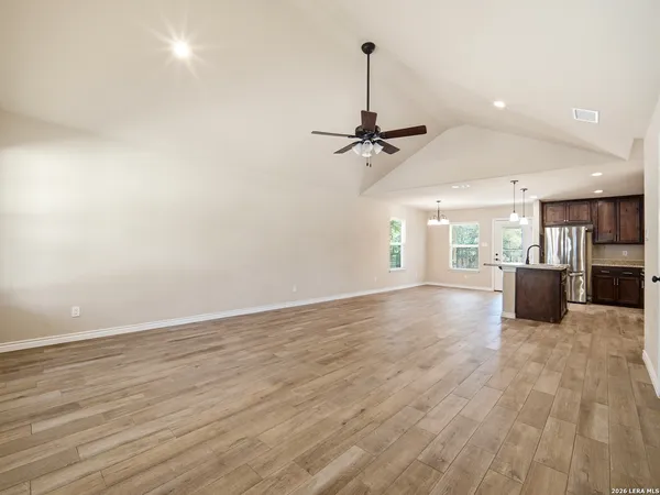 a view of a room with stainless steel appliances wooden floor and chandelier