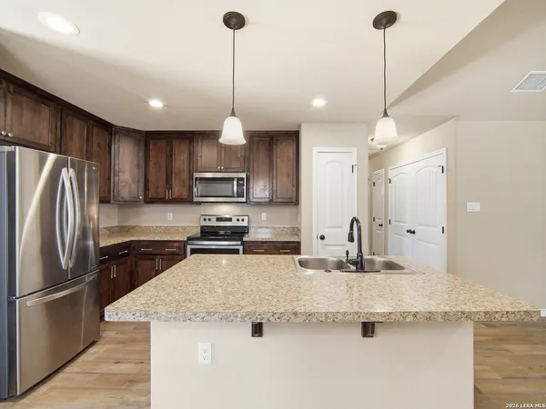 a kitchen with kitchen island granite countertop stainless steel appliances and a sink