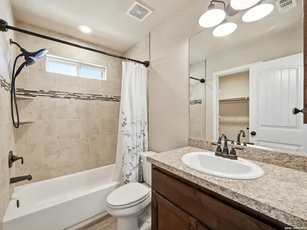 a bathroom with a granite countertop sink a toilet and shower