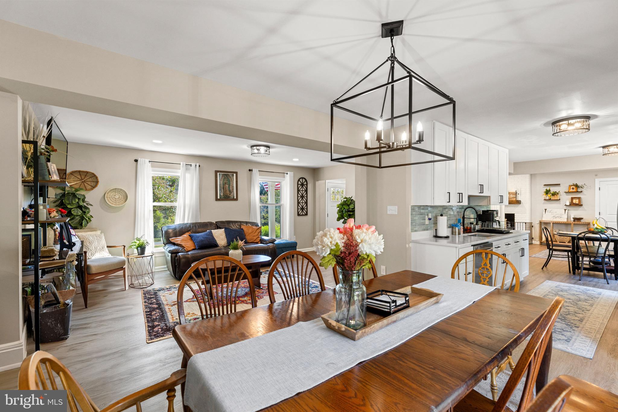 6666 Kelly Road Warrenton, VA 20187 - Photo 5 of 34 a view of a dining room and livingroom with furniture wooden floor a chandelier