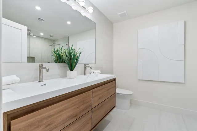 a bathroom with a toilet sink and mirror
