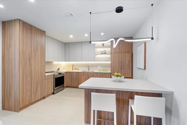 a kitchen with kitchen island a stove a sink and a refrigerator