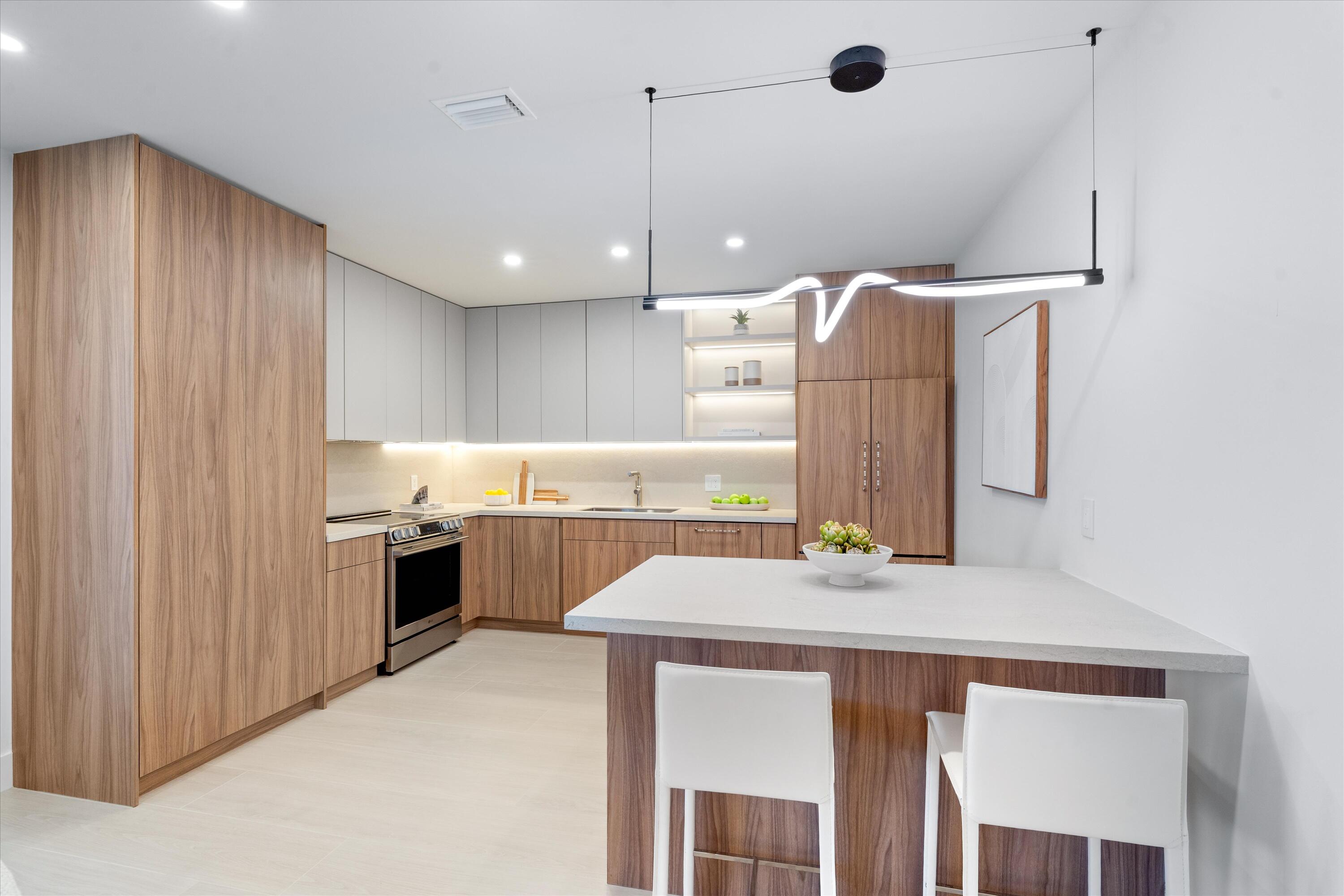 5154 Lake Catalina Drive, Unit A Boca Raton, FL 33496 - Photo 2 of 51 a kitchen with kitchen island a stove a sink and a refrigerator