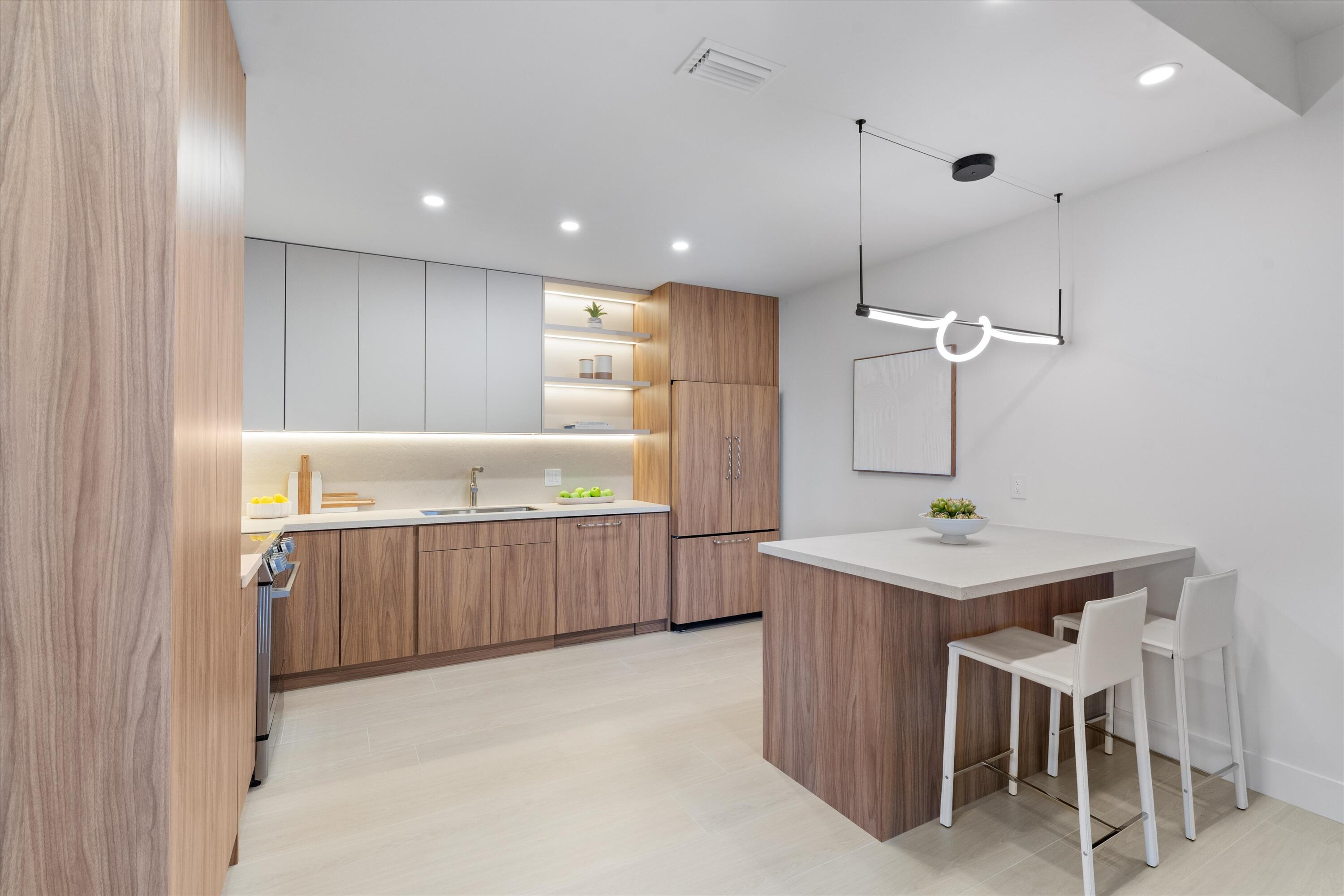 5154 Lake Catalina Drive, Unit A Boca Raton, FL 33496 - Photo 3 of 51 a kitchen with a table chairs sink and wooden floor