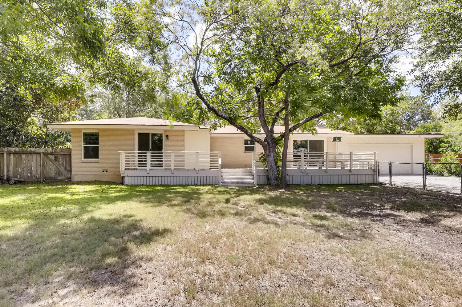 446 Pike Road San Antonio, TX 78209 - Photo 27 of 28 A welcoming front deck spans the facade of this single-story home, nestled among mature trees.