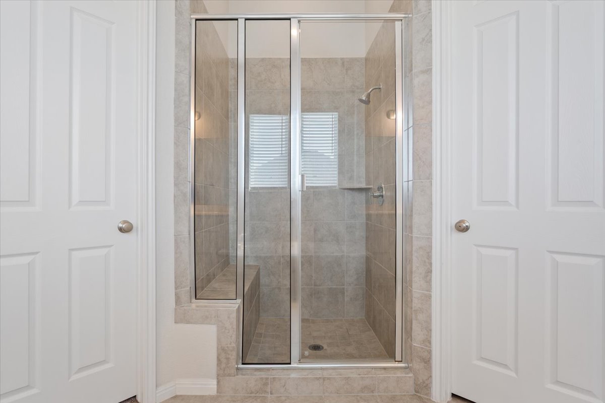 3625 Garrano Bend Leander, TX 78641 - Photo 18 of 38 A well-lit, tiled shower with clear glass enclosure and built-in bench creates a refreshing bathing experience.