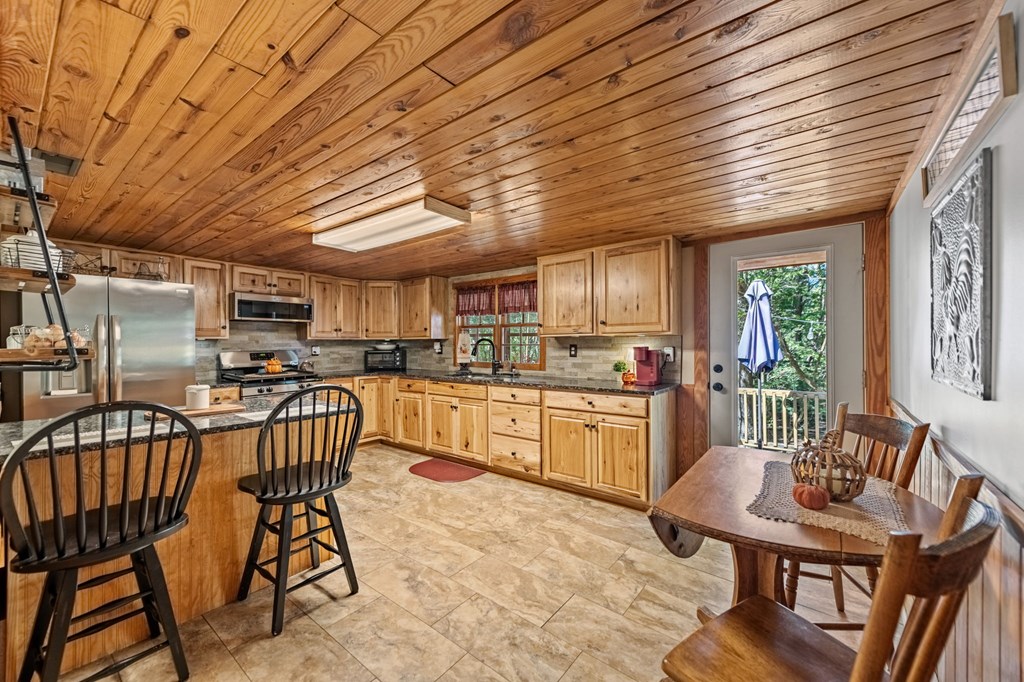 134 Ebenezer Road Ellijay, GA 30536 - Photo 23 of 85 a open kitchen with stainless steel appliances granite countertop a kitchen island a table and chairs
