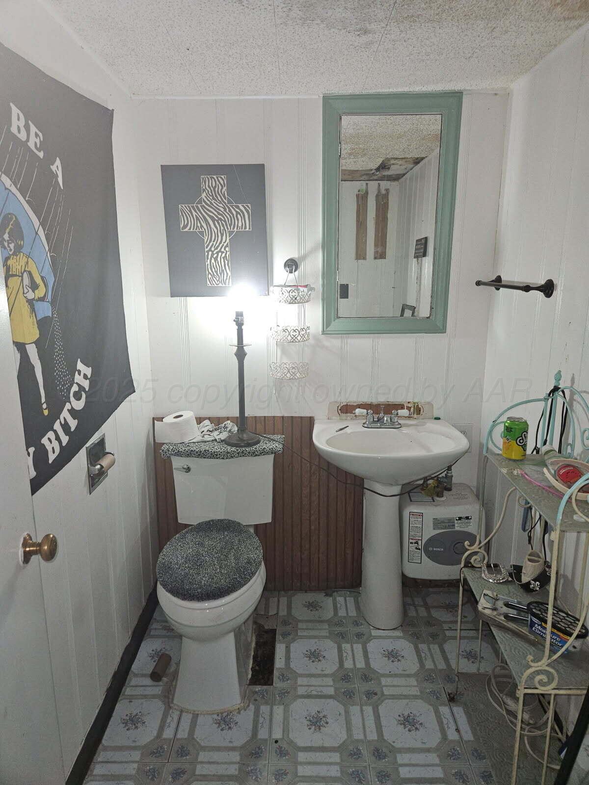 418 South Main Street Borger, TX 79007 - Photo 23 of 41 a bathroom with a toilet a sink and mirror