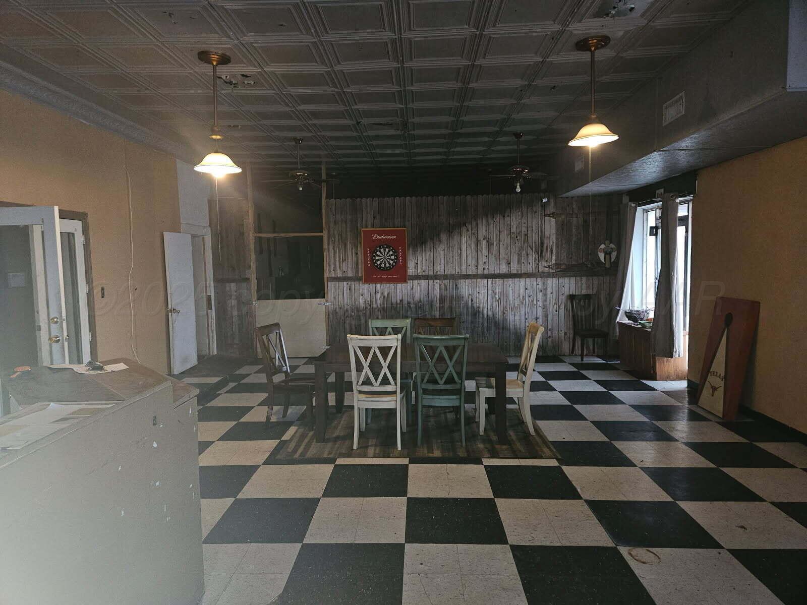 418 South Main Street Borger, TX 79007 - Photo 4 of 41 a room with a black white checkered floor with a gaming machine and dining table