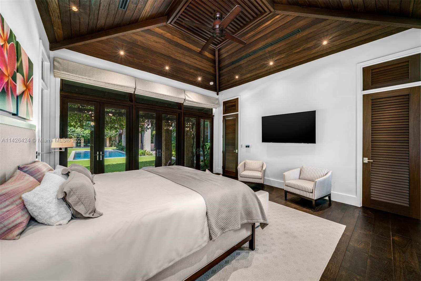 8601 Ponce De Leon Road Miami, FL 33143 - Photo 12 of 39 a spacious bedroom with a bed and a flat screen tv