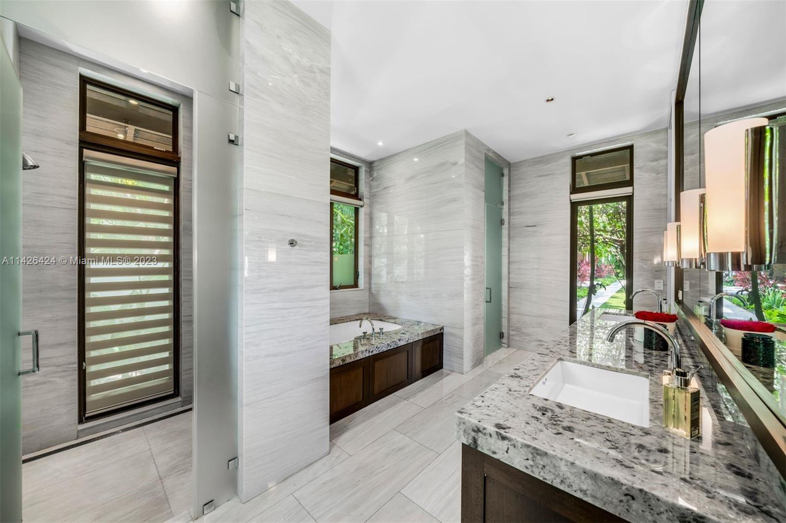 8601 Ponce De Leon Road Miami, FL 33143 - Photo 13 of 39 a bathroom with a granite countertop sink and a mirror