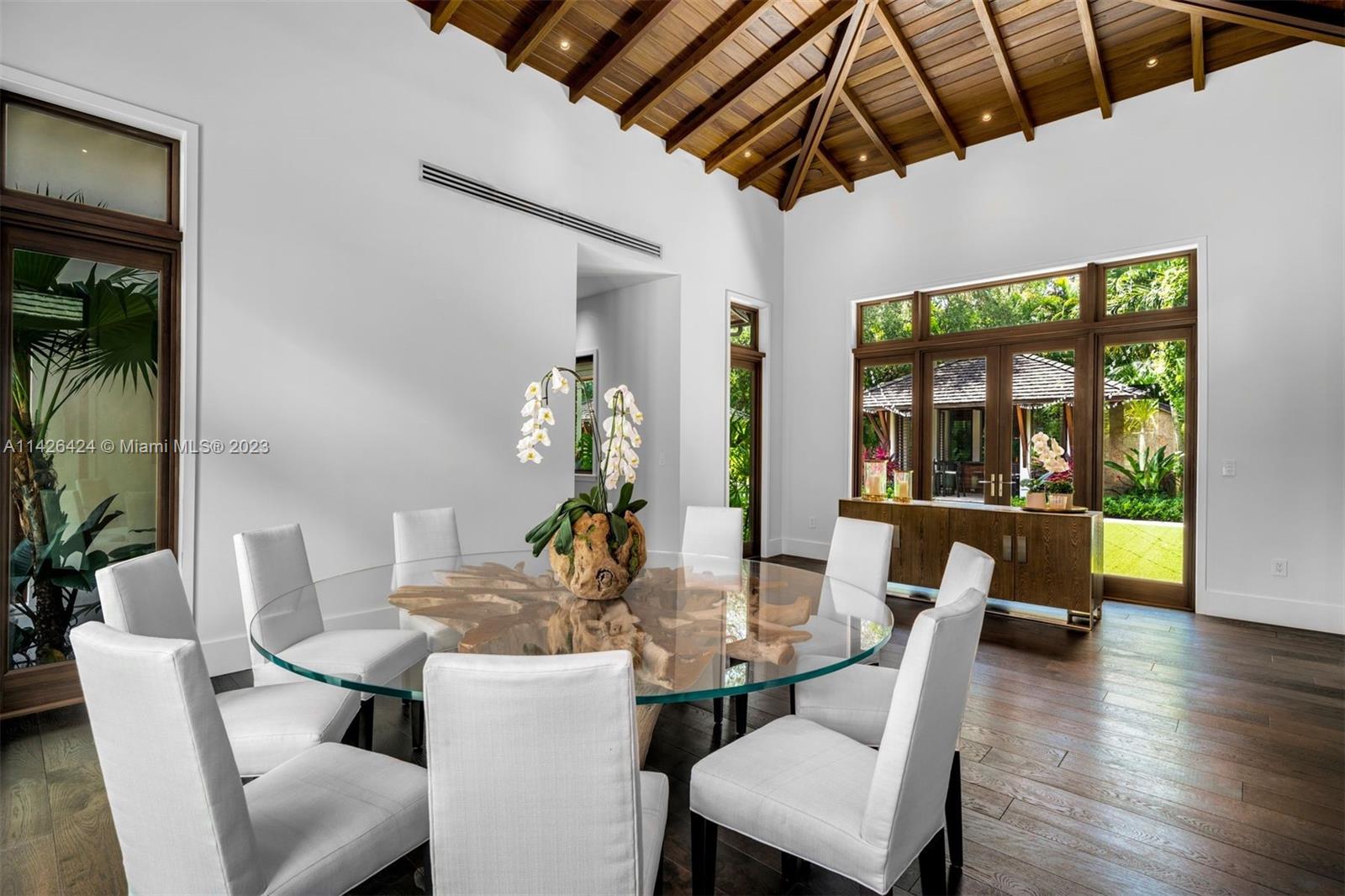 8601 Ponce De Leon Road Miami, FL 33143 - Photo 31 of 39 a dining room with furniture wooden floor a potted plant and a chandelier