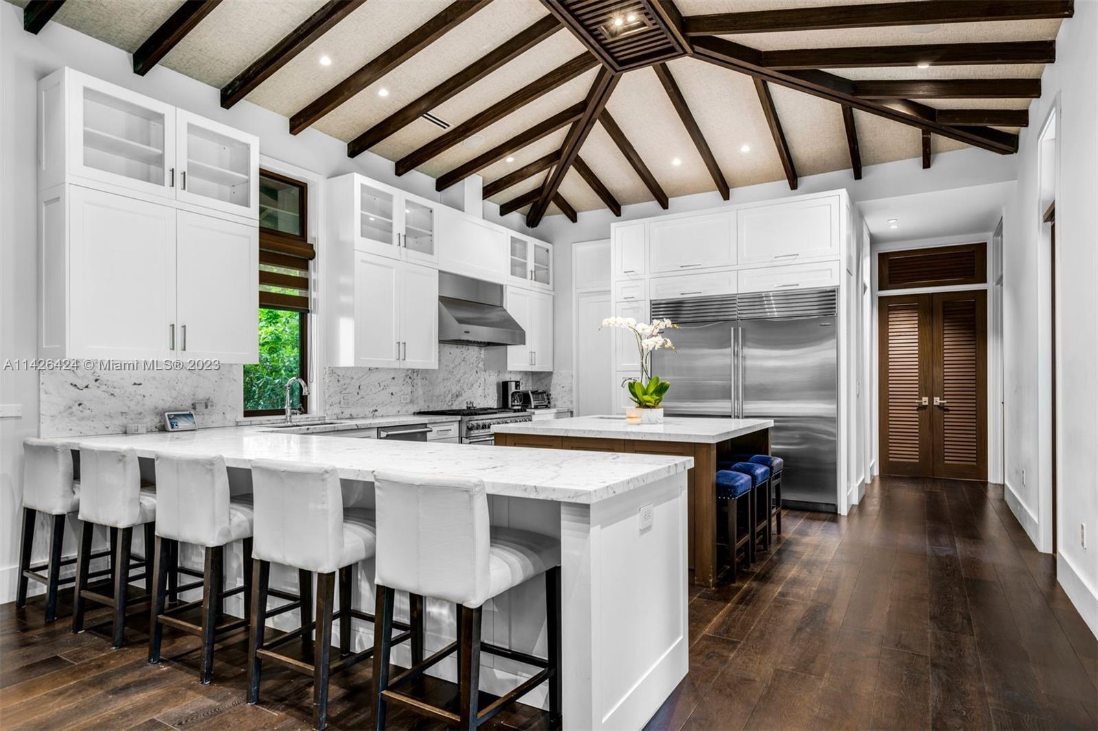 8601 Ponce De Leon Road Miami, FL 33143 - Photo 7 of 39 a kitchen with a sink chairs and wooden floor