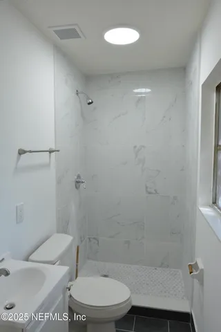 a bathroom with a toilet and a shower