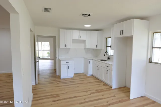 a kitchen with white cabinets and white appliances