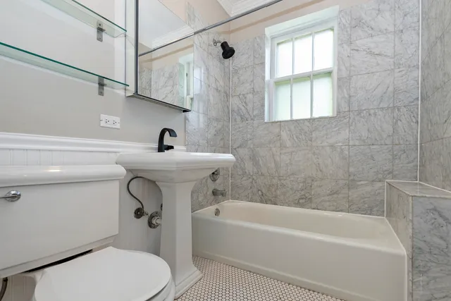 a bathroom with a sink a bathtub and a window