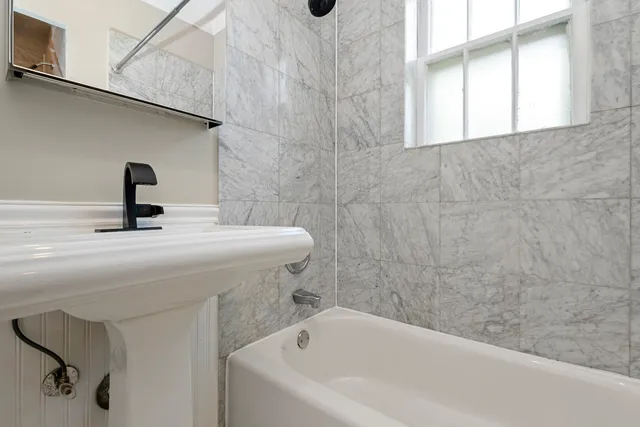 a white toilet sitting next to a white bath tub