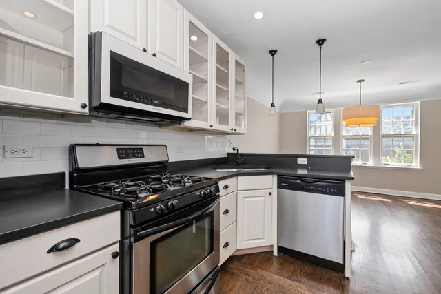 a kitchen with stainless steel appliances a stove a refrigerator and a sink