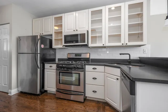 a dining room with wooden floor a chandelier a wooden table and chairs
