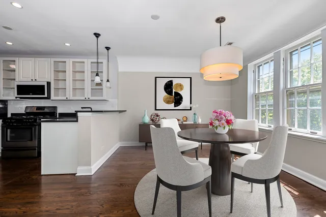 a open kitchen with stainless steel appliances granite countertop a refrigerator a oven a sink a stove and white cabinets with wooden floor