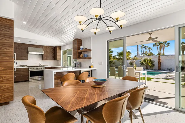 a living room with lots of furniture and a dining table with kitchen view