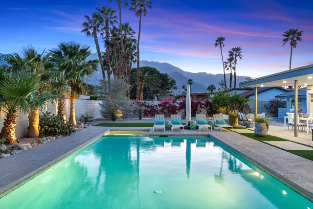 a living room with furniture kitchen view and a large window