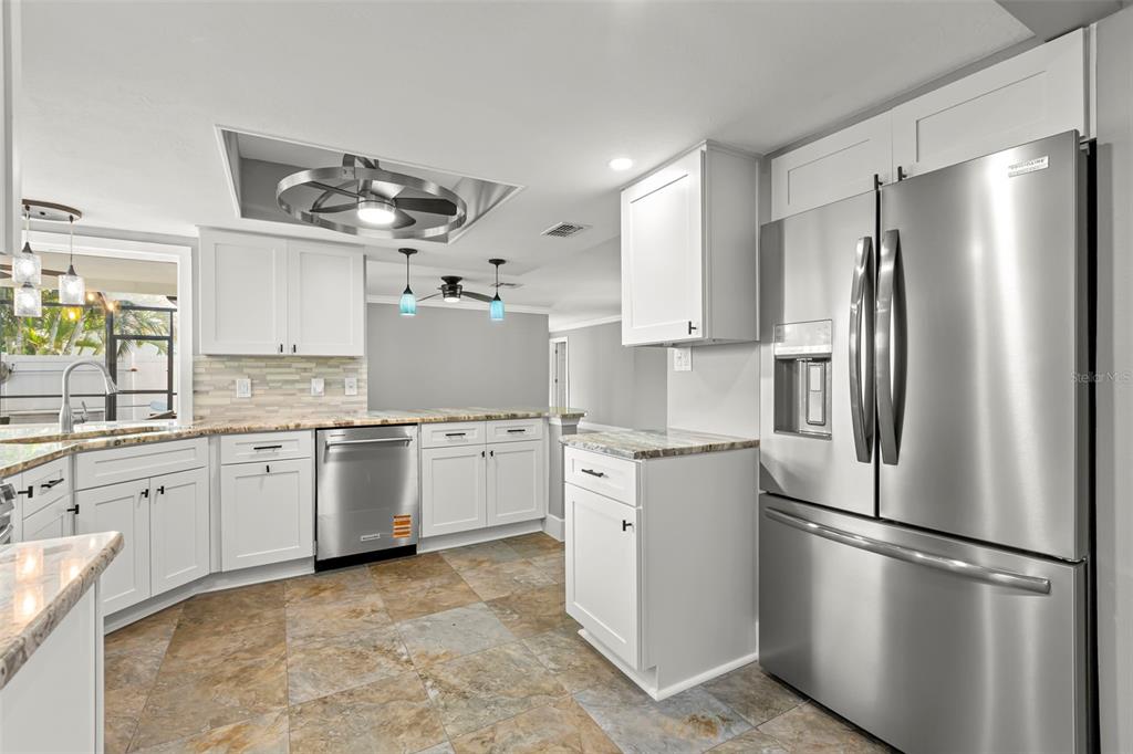 4003 Headsail Drive New Port Richey, FL 34652 - Photo 15 of 50 a kitchen with granite countertop stainless steel appliances a refrigerator sink and cabinets