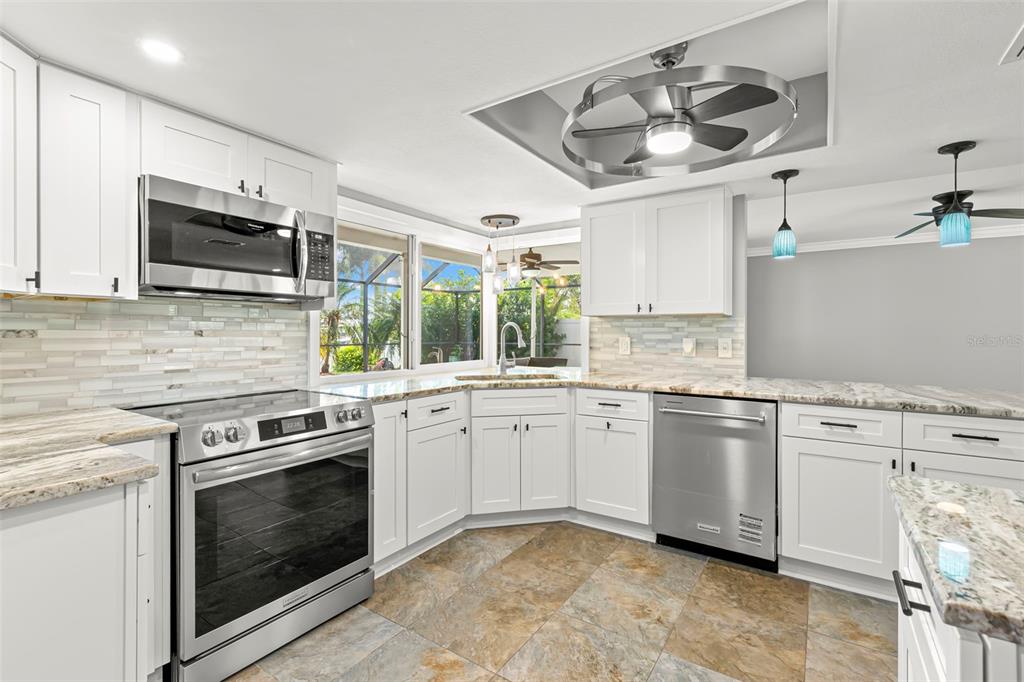 4003 Headsail Drive New Port Richey, FL 34652 - Photo 16 of 50 a kitchen with stainless steel appliances granite countertop a stove sink and microwave