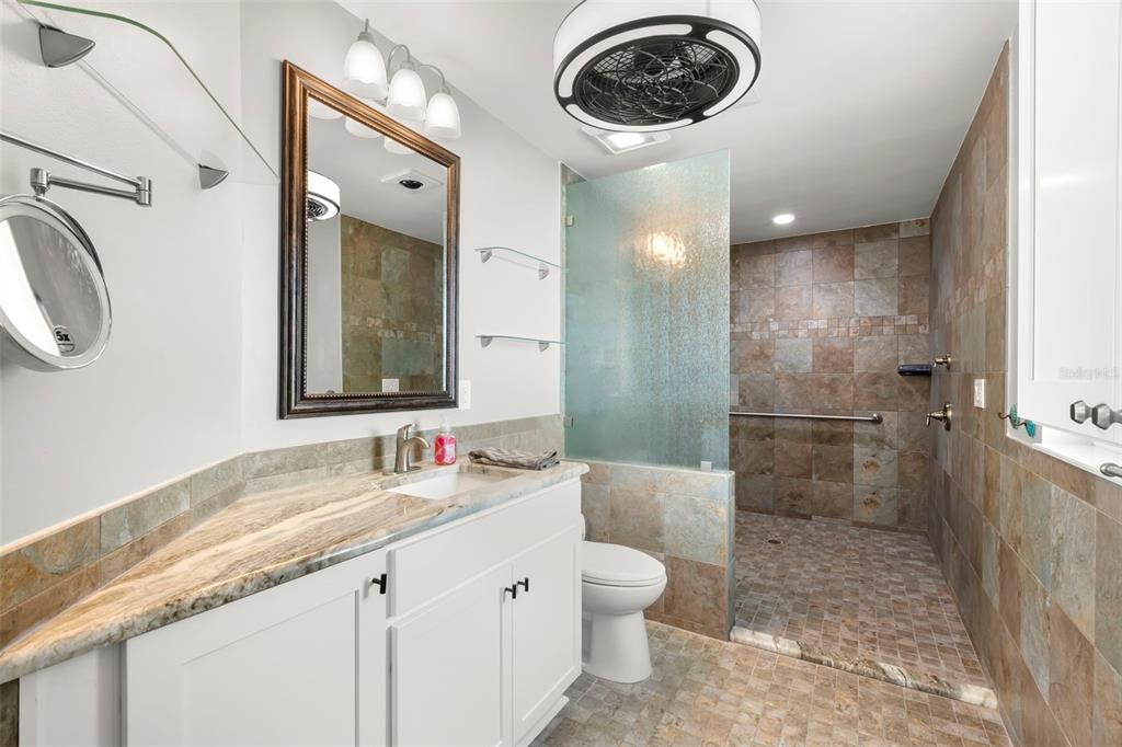 4003 Headsail Drive New Port Richey, FL 34652 - Photo 32 of 50 a bathroom with a granite countertop sink a toilet and a shower