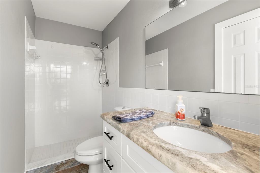 4003 Headsail Drive New Port Richey, FL 34652 - Photo 37 of 50 a bathroom with a granite countertop sink mirror vanity and toilet
