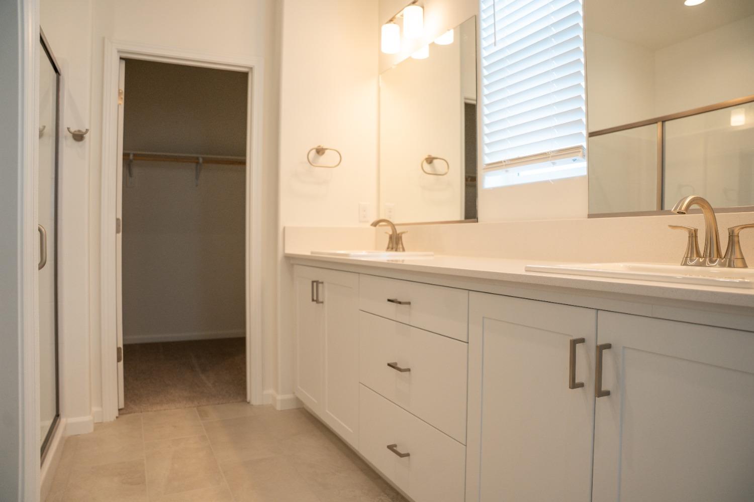 694 Thomas Way Madera, CA 93636 - Photo 14 of 27 a bathroom with a double vanity sink and mirror