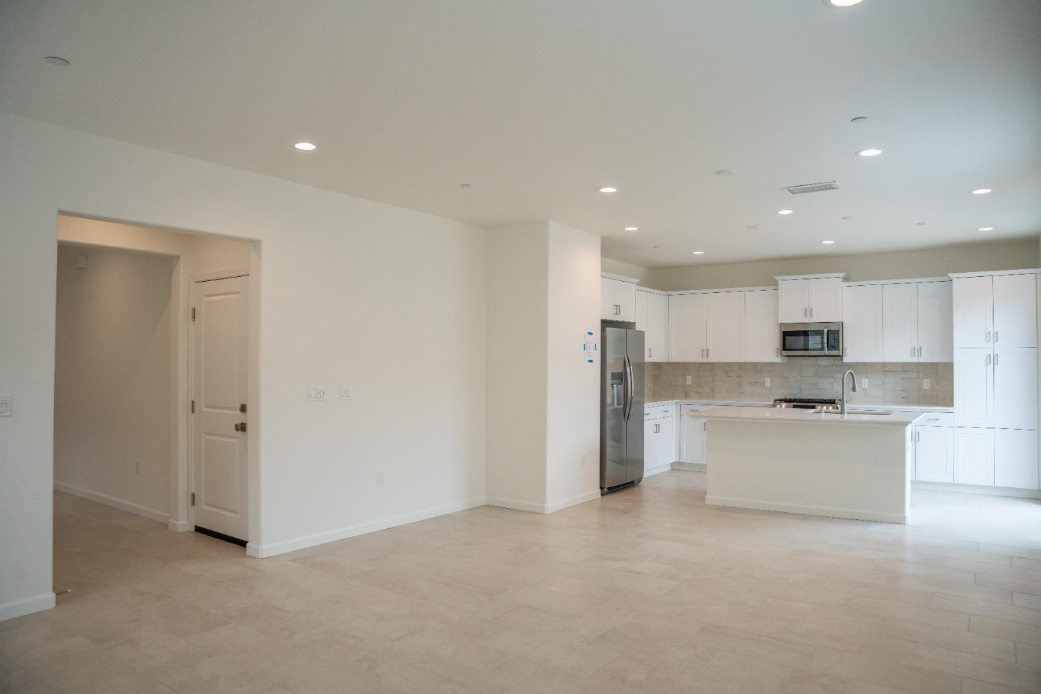 694 Thomas Way Madera, CA 93636 - Photo 3 of 27 a view of a kitchen with a sink and dishwasher a refrigerator with white cabinets