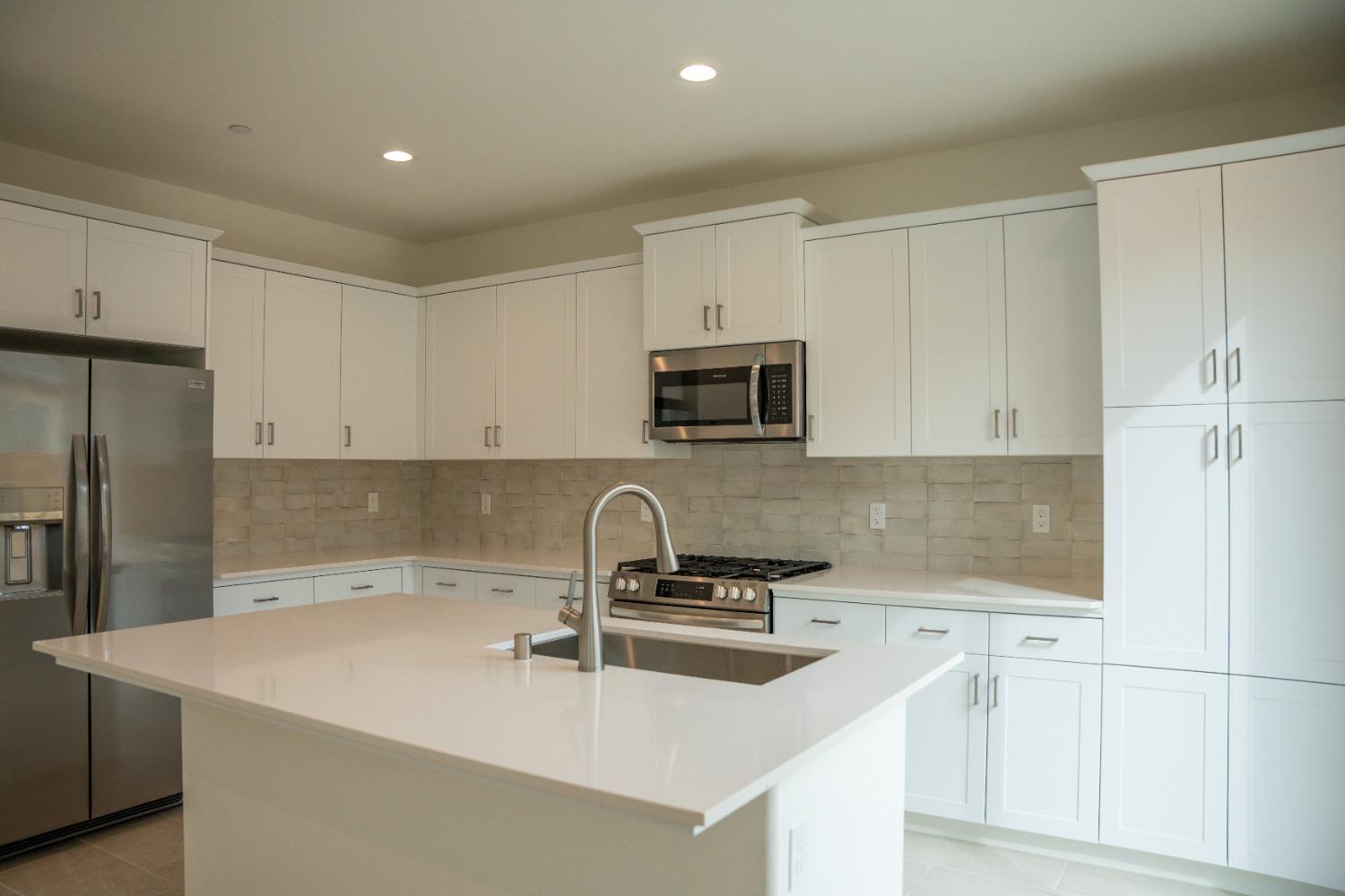 694 Thomas Way Madera, CA 93636 - Photo 4 of 27 a kitchen with stainless steel appliances a sink a stove a microwave a sink a refrigerator and cabinets