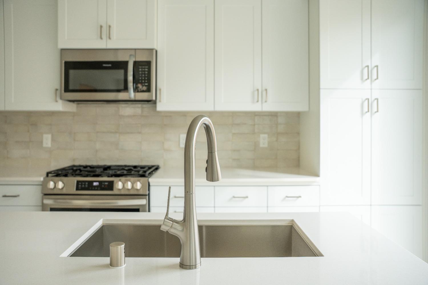 694 Thomas Way Madera, CA 93636 - Photo 6 of 27 a kitchen with a sink a microwave and cabinets