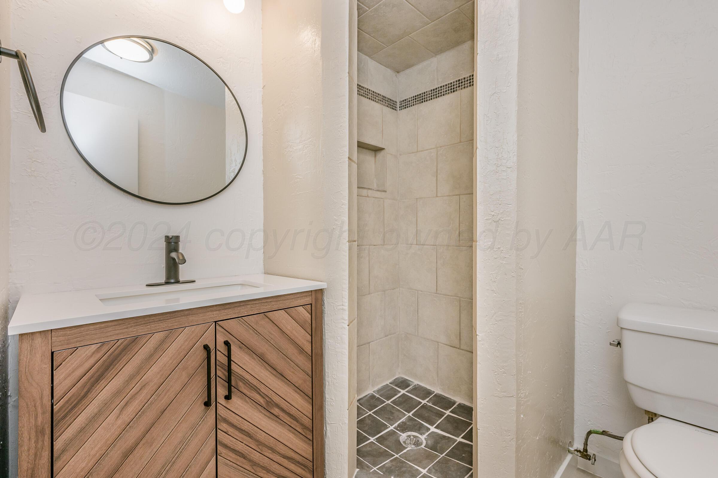 2115 South Hayden Street Amarillo, TX 79109 - Photo 13 of 27 a bathroom with a sink mirror and toilet