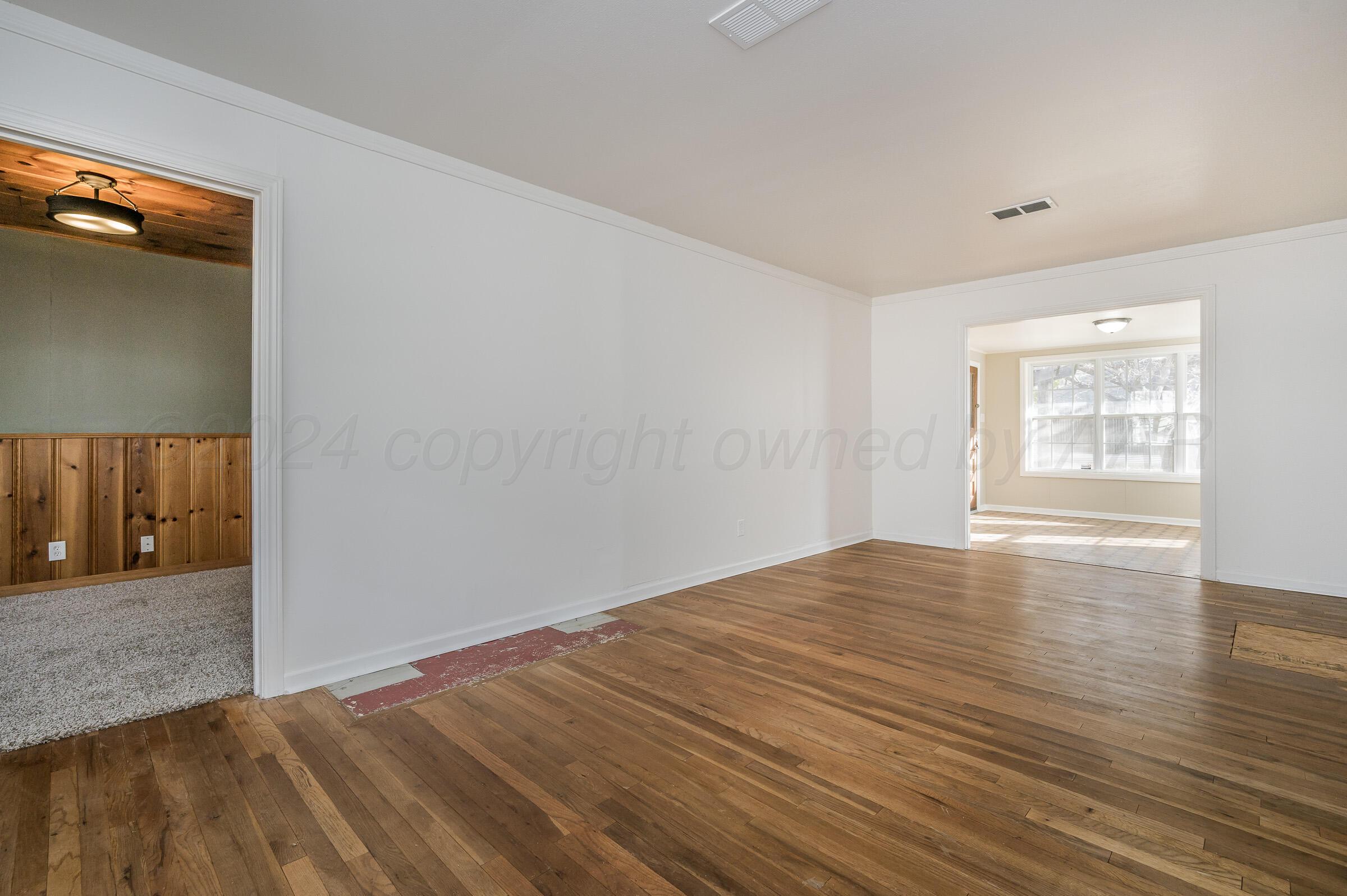 2115 South Hayden Street Amarillo, TX 79109 - Photo 6 of 27 a view of an empty room with wooden floor and a window