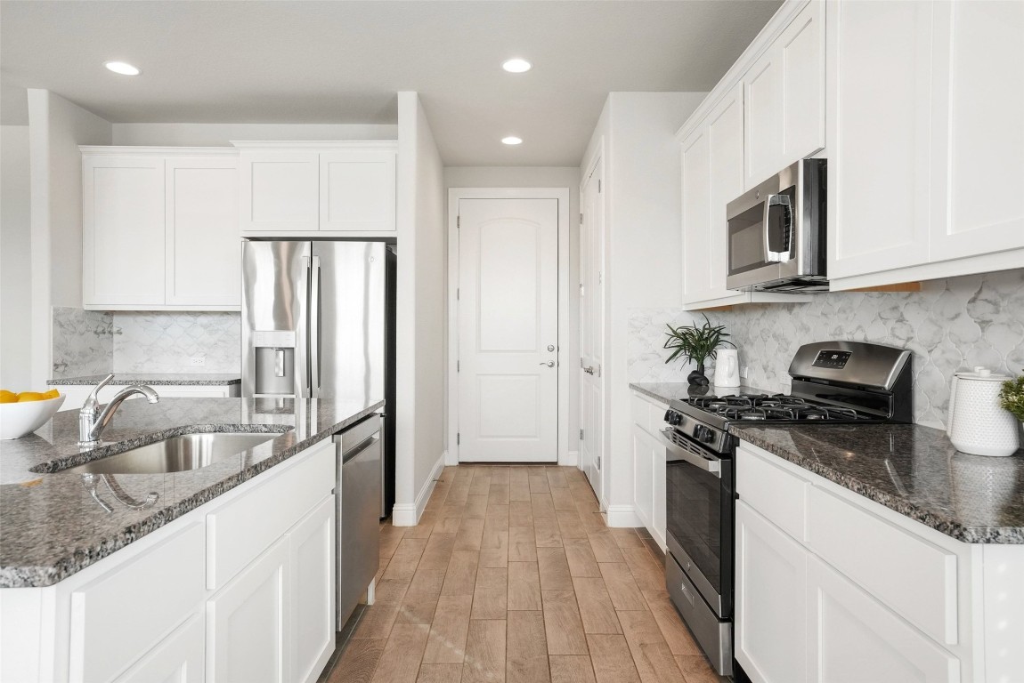 113 Stone Cyn Drive Georgetown, TX 78628 - Photo 11 of 35 a kitchen with stainless steel appliances granite countertop a sink stove and refrigerator