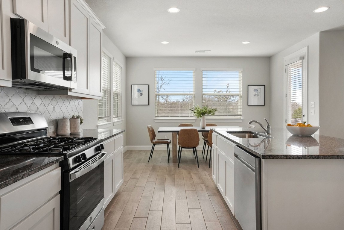 113 Stone Cyn Drive Georgetown, TX 78628 - Photo 13 of 35 a kitchen with stainless steel appliances granite countertop a stove a sink and a microwave