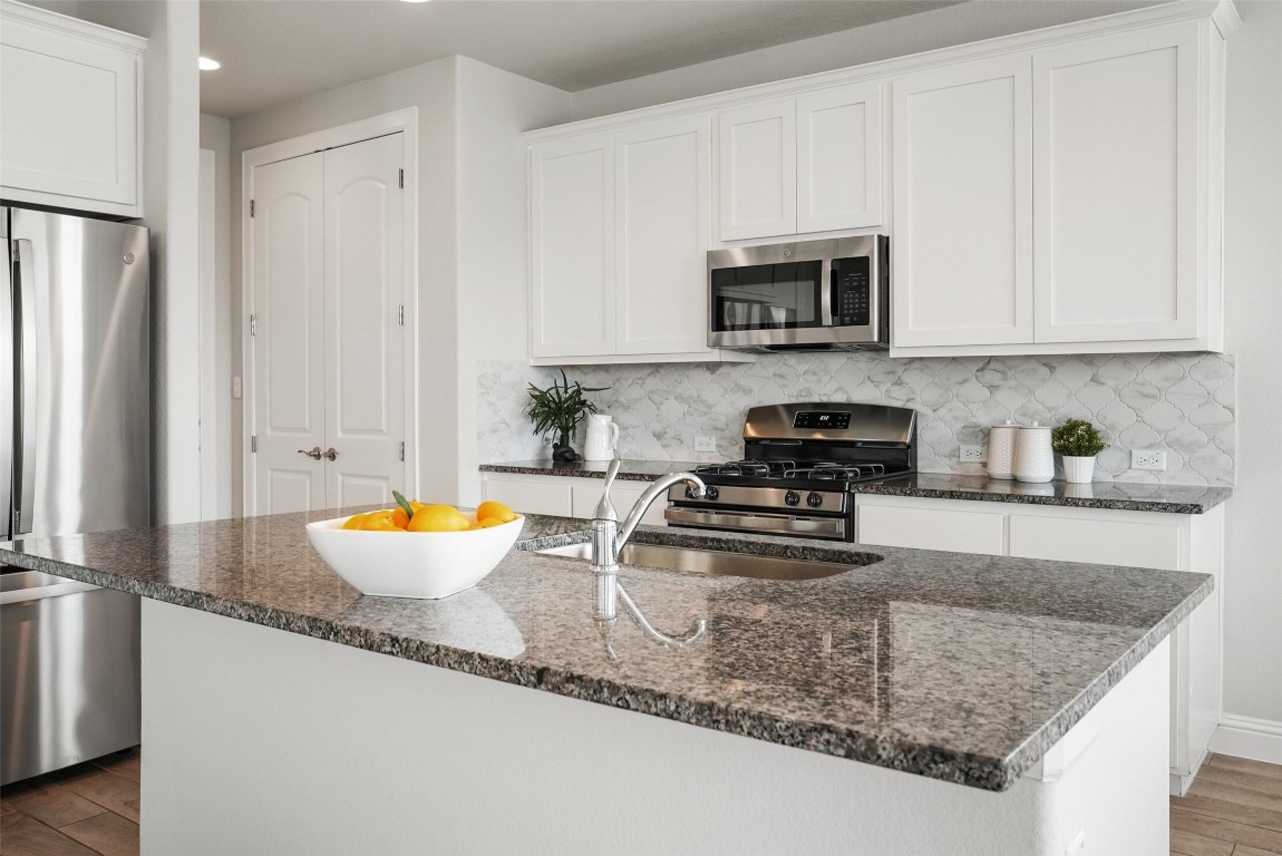 113 Stone Cyn Drive Georgetown, TX 78628 - Photo 10 of 35 a kitchen with stainless steel appliances granite countertop a sink stove and refrigerator